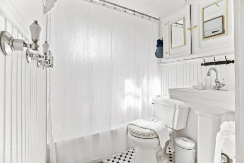 Baño blanco con aseo y lavamanos en Cottage Serenity Haven en Barnstable