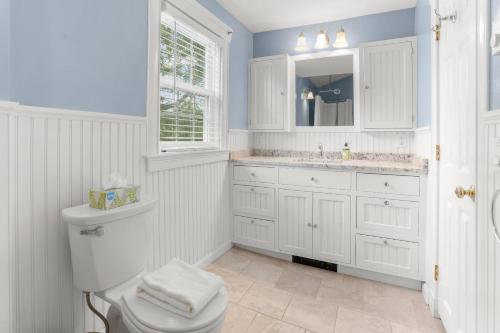 a white bathroom with a toilet and a sink at Experience Cape Cod Magic Stay in Hyannis, Where Memories Are Made in Barnstable