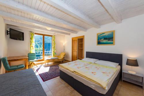 1 dormitorio con 1 cama, escritorio y TV en Hotel Modrin-Wellness, en Trutnov