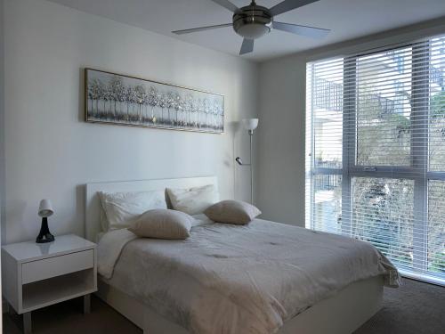 a white bedroom with a bed and a ceiling fan at LUXURY APARTMENT IN HOLLYWOOD in Los Angeles