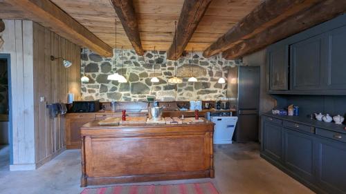una gran cocina con una isla de madera en el centro en LE BURON DE PERRIER, en Saint-Urcize