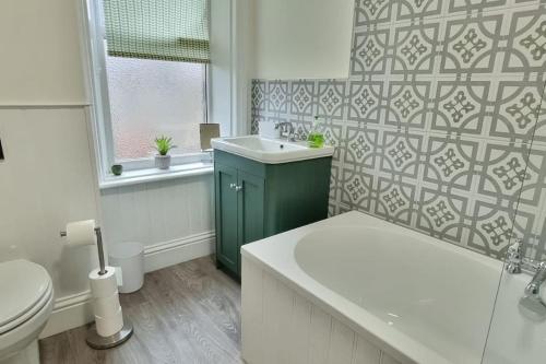 łazienka z umywalką, toaletą i oknem w obiekcie Dale Cottage Cozy 3 Bedroom nr Ilkley - West Yorkshire w mieście Burley in Wharfedale