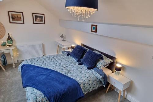 Un dormitorio con una cama azul con sábanas y almohadas azules en Dale Cottage Cozy 3 Bedroom nr Ilkley - West Yorkshire en Burley in Wharfedale