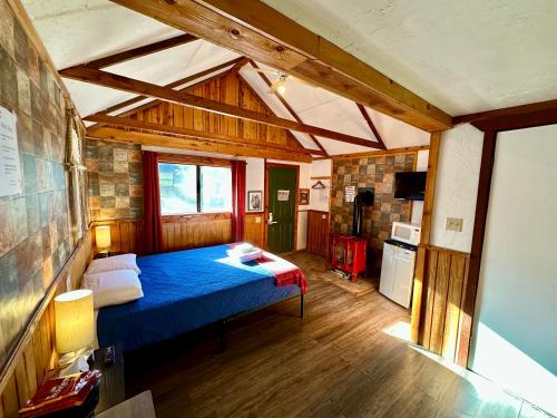 ein Schlafzimmer mit einem blauen Bett in einem Zimmer in der Unterkunft The Village Cabins in Big Bear Lake