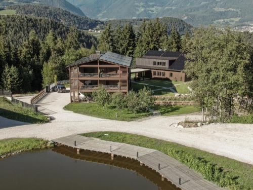 an aerial view of a house with a lake at Arieshof Castell in San Lorenzo di Sebato