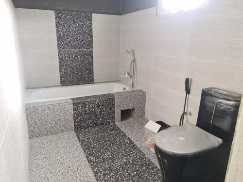 a bathroom with a bath tub and a toilet at Villa de luxe Domaine Léna vue sur mer in Foulpointe