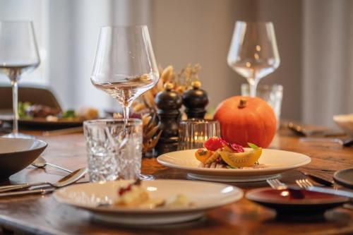 a table with plates of food and a glass of wine at Arieshof Castell in San Lorenzo di Sebato