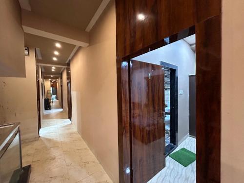un pasillo con una puerta de madera en una casa en Hotel New agrawal pudi bhandar, en Hoshangābād