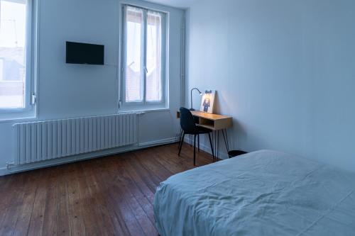 ein Schlafzimmer mit einem Bett und einem Schreibtisch mit einem Stuhl in der Unterkunft La Saint-Quentinoise chambre privée amande in Saint-Quentin