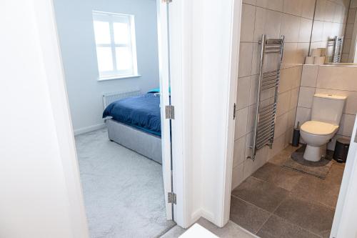 a bathroom with a bed and a toilet in a room at Private room in a new build in Heanor
