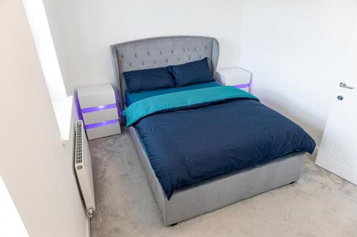 a bedroom with a bed with a blue comforter at Private room in a new build in Heanor