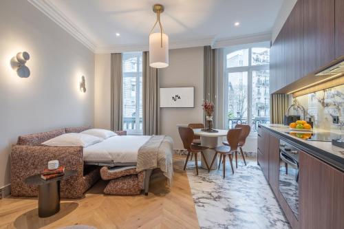 a bedroom with a bed and a kitchen with a table at Yuna Saint-Germain-des-Prés - Serviced Apartments in Paris