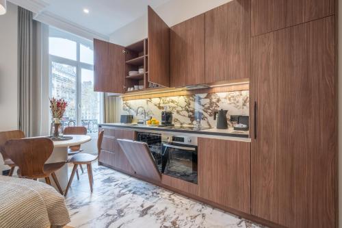 uma cozinha com armários de madeira e uma sala de jantar em Yuna Saint-Germain-des-Prés - Serviced Apartments em Paris