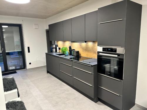 a kitchen with black cabinets and a stove top oven at Luxuriöses Apartment direkt am Kanal 125 m² - youpartments in Münster