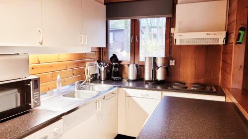 a kitchen with white cabinets and a sink at Chalet La Boverie 195 in Rendeux