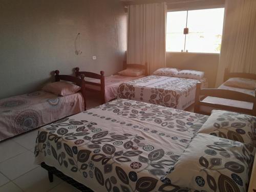 a group of three beds in a room at Casalagoana in Marechal Deodoro