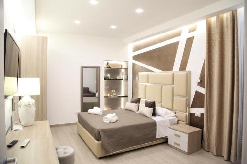 a bedroom with a bed and a desk and a mirror at Royal Dreams in Caserta