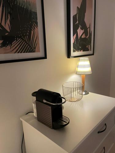 una cómoda blanca con una tostadora encima en Privates Zimmer in einem gepflegten Bungalow, en Neuss