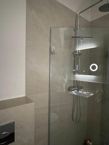 baño con ducha y puerta de cristal en Privates Zimmer in einem gepflegten Bungalow, en Neuss