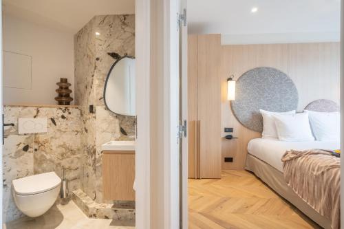 une chambre d'hôtel avec un lit et une salle de bain dans l'établissement Yuna Saint-Germain-des-Prés - Serviced Apartments, à Paris