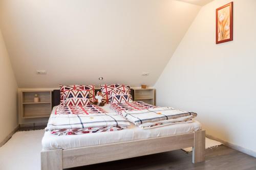 a bedroom with a bed with red and white pillows at Kevikincses Vendégház in Túrkeve