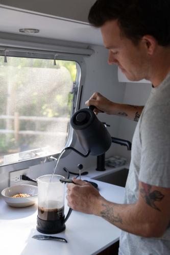 un uomo sta versando una bevanda in una tazza di AutoCamp Asheville ad Asheville