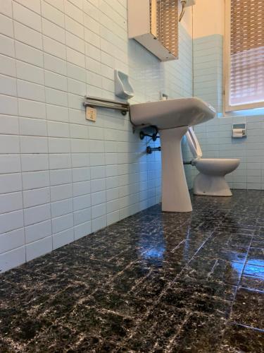 La salle de bains est pourvue d'un lavabo et de toilettes. dans l'établissement PRINCIPE ROOMS, à Rodigo