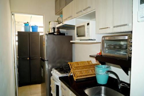 une cuisine avec un évier et un réfrigérateur en acier inoxydable dans l'établissement Penthouse con Jacuzzi en Acapulco Diamante, à Acapulco