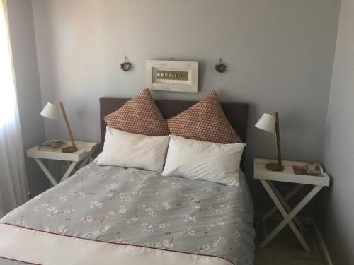 um quarto com uma cama com almofadas e duas mesas em Breede View em Kontiki