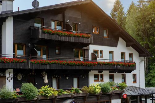 a black and white building with flowers on balconies at Canisiusbrünnl Self- Check in in Innsbruck