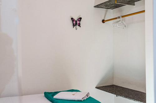 um quarto branco com uma borboleta na parede em Residencial Ilha do Sol em Arraial d'Ajuda
