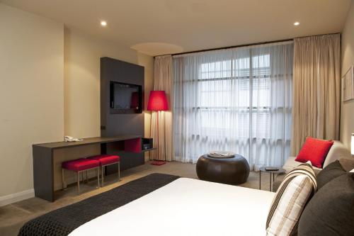 a hotel room with a large bed and a tv at Mantra Hindmarsh Square in Adelaide