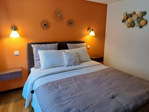 ein Schlafzimmer mit einem großen Bett mit orangefarbenen Wänden in der Unterkunft Gîte Entre Vignes et Vergers maison historique in Gueberschwihr