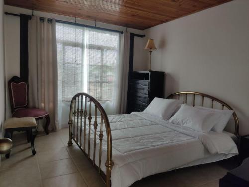 - une chambre avec un lit, une fenêtre et une chaise dans l'établissement Casa Vacacional cerca al Parque del Café, à Montenegro