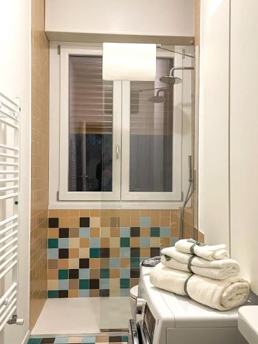 a bathroom with a sink and a mirror and towels at [Rho Fiera – Milano] Teal Apartment in Cornaredo