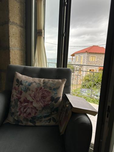 a book sitting on a couch next to a window at Μαϊστράλι in Kotrónion