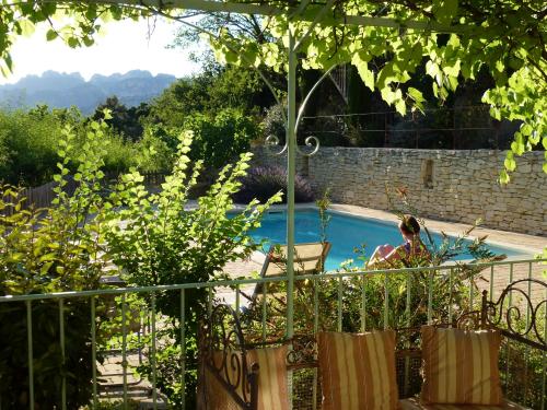 une femme assise sur une chaise à côté d'une piscine dans l'établissement Aux Dentelles, à La Roque-Alric