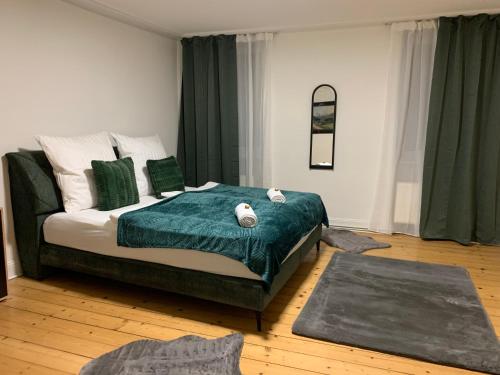 a bedroom with a bed with green and white pillows at BK Apartments in Lörrach