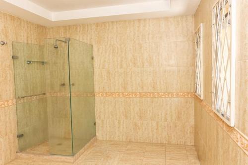 a shower with a glass door in a bathroom at Apartahotel Romor in Cali