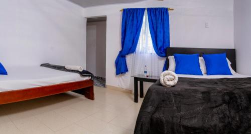 a bedroom with two beds and a window with blue pillows at Secretos del Eden in Ruiosucio