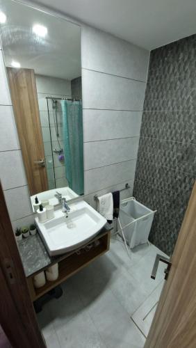 a bathroom with a sink and a mirror at Cosy Appartement Au Centre de Casablanca in Casablanca