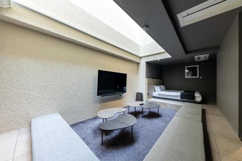 a room with a bed and two tables and a tv at 2269AZAVU in Tokyo
