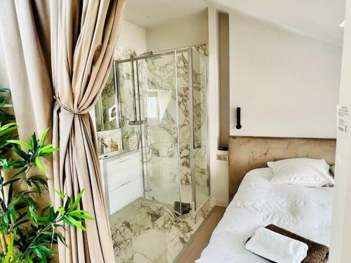 une chambre avec une douche en verre et un lit dans l'établissement Le StayParis - Charmant logement au cœur du Marais, à Paris
