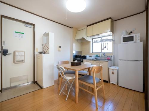 La cuisine est équipée d'une table, de chaises et d'un réfrigérateur. dans l'établissement maison elegance - Vacation STAY 15799, à Tokyo