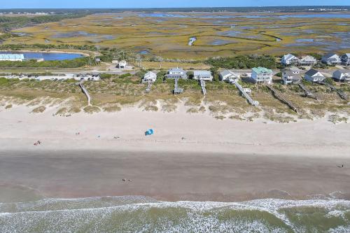an aerial view of a beach with houses and the ocean at Fairwinds by Oak Island Accommodations in Caswell Beach