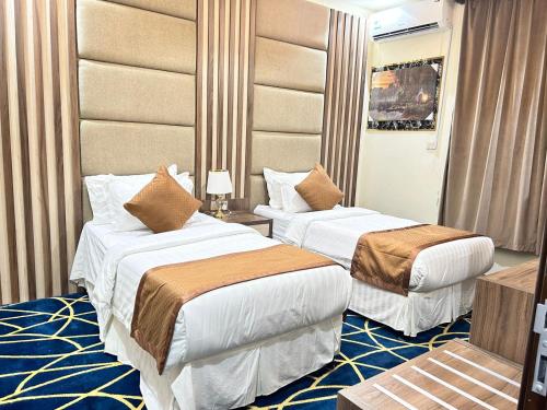 a hotel room with two beds in a room at شقق ريجنسي للشقق المخدومة in Jazan