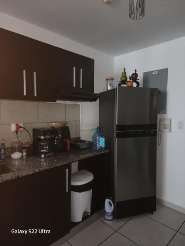 a kitchen with black cabinets and a black refrigerator at Casa Hany in Panama City