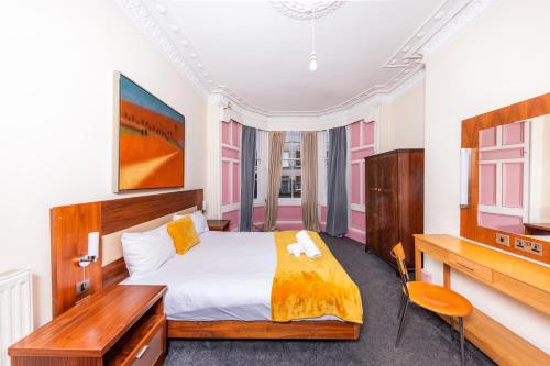 een slaapkamer met een groot bed en een televisie bij Super Central 4 Bedrooms Apartment by Calton Hill in Edinburgh