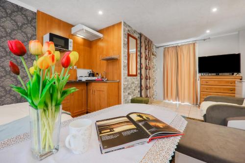 a living room with a table with a book and flowers at Pokoje u Pawloka in Ciche