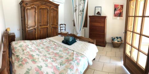 une chambre avec un lit et une commode en bois dans l'établissement La maison des Sources, à Salon-de-Provence
